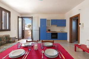 a dining room with a table and a kitchen at L'Agrumeto a Marittima by BarbarHouse in Marittima