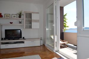 a living room with a tv and a sliding glass door at Apartment Roxy in Zadar