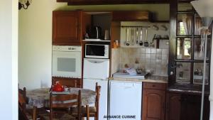 una cocina con electrodomésticos blancos y una mesa pequeña. en Gîte Aubance 5 Places Moulin de la Placette en Faye-dʼAnjou