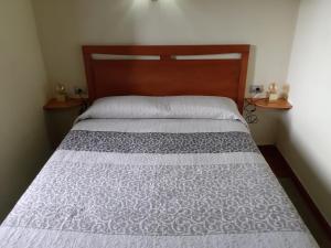 a bed with a wooden headboard in a bedroom at Casa Rural Los Perales in Mocanal