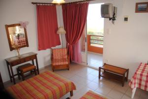 a room with a bedroom with a bed and a tv at Maria Rooms in Agia Ermioni