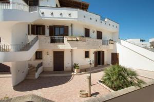 a large white building with stairs and a balcony at L'Agrumeto a Marittima by BarbarHouse in Marittima