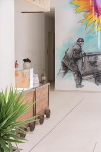 a room with a painting of a man working at La Mina Hostal Boutique in Conil de la Frontera