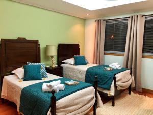 een slaapkamer met 2 bedden en handdoeken bij Quinta Da Bela Vista in Ponta Delgada