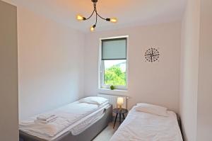 a bedroom with two beds and a window at Apartament RELAKS w spokojnej okolicy - SUN&SPORT in Szczyrk