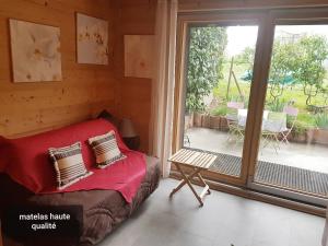 a bedroom with a bed and a sliding glass door at Chaleureux 2 pièces avec terrasse à Seez in Séez