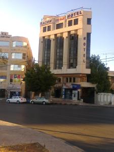 een gebouw waar auto's voor geparkeerd staan bij Razan Hotel in Amman
