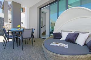 a wicker bed in a room with a table and chairs at Villa Melody in Protaras