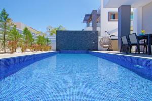a swimming pool in a villa with a blue tile floor at Villa Melody in Protaras