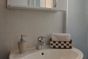 um lavatório de casa de banho com duas torneiras e um cesto em Suite Montegrappa em Palermo
