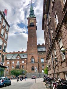 um grande edifício de tijolos com uma torre de relógio em A Charming and Beautiful Oasis in the Heart of Copenhagen em Copenhague