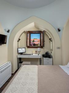 Schlafzimmer mit einem Bett und einem Schreibtisch mit einem Spiegel in der Unterkunft BIBLIOTHEQUE in Rhodos (Stadt)