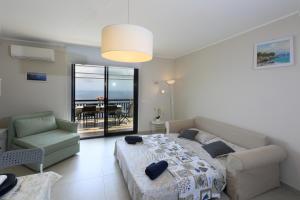 una camera da letto con un letto, un divano e una sedia di Olimpia's House a Taormina