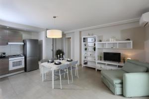 una cucina e un soggiorno con un tavolo e un divano di Olimpia's House a Taormina Altre 24 foto