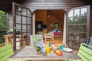 einen Holztisch auf der Veranda eines Hauses in der Unterkunft Cabane de La Mésange in Auriac-du-Périgord