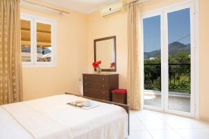 a bedroom with a bed and a large window at Vaso apartments in Nydri
