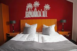 1 dormitorio con 1 cama blanca grande y 2 lámparas en Hotel & Restaurant Am Bodden, en Putbus