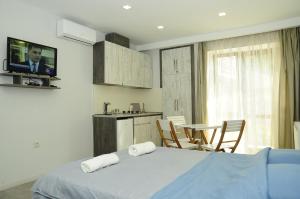 a bedroom with a bed and a kitchen with a tv at Borjomi Apartments Apart Hotel in Borjomi
