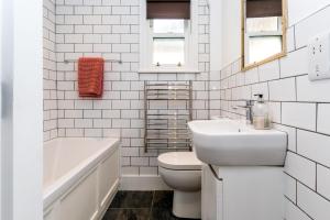a white bathroom with a sink and a toilet and a tub at City Apartments - Priory Street in York