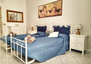 twee bedden in een slaapkamer met blauw en wit bij Casa Scalini in Como