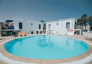 a large swimming pool in front of a building at Apartamentos Punta Elena Beach in Corralejo