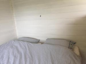 a bed in a room with two pillows on it at VierVaart Veldhuisje TERRA in Groede
