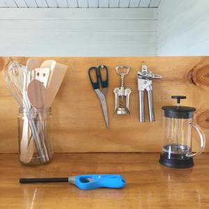 a wooden cutting board with utensils and a blender at VierVaart Veldhuisje TERRA in Groede