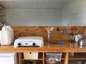 a kitchen counter with a toaster and utensils at VierVaart Veldhuisje TERRA in Groede