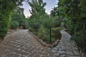 a cobblestone road with trees and plants on it at Mountain Breeze Lodge & Resort in Al Salt