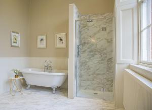 a bathroom with a tub and a glass shower at The Sculleries at Thirlestane Castle in Lauder