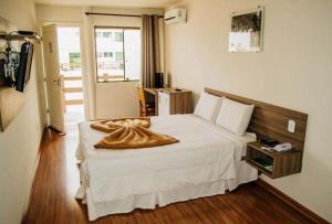 a hotel room with a bed with a blanket on it at Dalle Hotel in Bagé