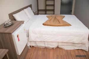 a bedroom with a large white bed and a wooden floor at Dalle Hotel in Bagé