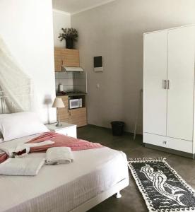 a bedroom with a large bed and a white cabinet at Paxos Bay Studios in Gaios