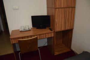 a wooden desk with a television on top of it at Centrum Konferencyjne IBIB PAN in Warsaw