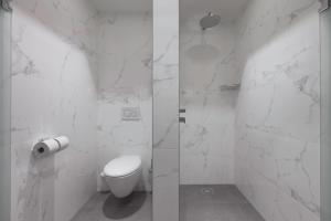 a white bathroom with a toilet and a shower at Grand Hotel Valies in Roermond