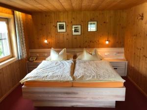 ein Schlafzimmer mit einem Bett in einem Holzzimmer in der Unterkunft Haus Gstüat in Lech am Arlberg