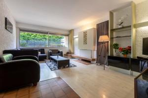 sala de estar con muebles y ventana grande en Villa PARADISE en Bartrés