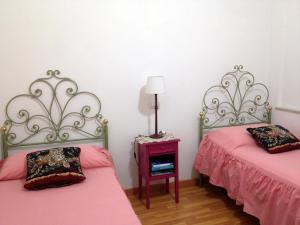 a room with two beds and a table with a lamp at Mavi's bedrooms in Lucca