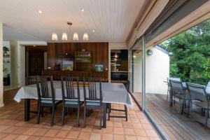Villa PARADISE في Bartrés: غرفة طعام ومطبخ مع طاولة وكراسي