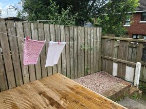 une clôture en bois avec des serviettes suspendues à une corde de corde à linge dans l'établissement Claire’s AirBNB 2, à Belfast