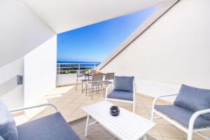 Un balcón con sillas y una mesa con vistas al océano. en Cap Homard - spacieux apt - magnifique vue mer -proche plage, en Saint-Gilles-les-Bains