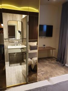 a bathroom with a sink, mirror and a bath tub at Vila Siago in Cluj-Napoca