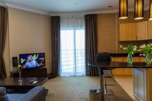 a living room with a couch and a tv at Kingsgate Hotel Doha by Millennium Hotels in Doha