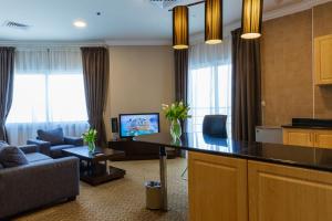 a living room with a couch and a table in a room at Kingsgate Hotel Doha by Millennium Hotels in Doha