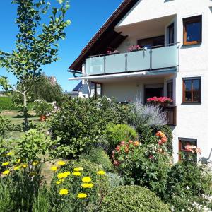 un giardino di fronte a una casa con fiori di Ferienwohnung Weigert a Sinzing