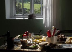 Peak Mazeri Guest House في Mazeri: طاولة عليها طعام مع نافذة