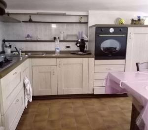 una cocina con armarios blancos y un aparato negro en Mansarda a 50 metri dal mare, en Porto SantʼElpidio