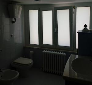 baño con aseo, 3 ventanas y radiador en Mansarda a 50 metri dal mare, en Porto SantʼElpidio