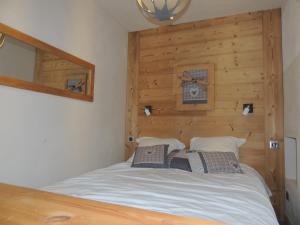uma cama num quarto com uma parede de madeira em LAUZIERE 1266/68 em Arc 1800