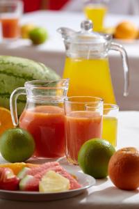 un plato de fruta y zumo y una jarra de zumo en ACK Resort Salama en Salama